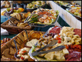 appetizer party featuring trays of hummus and pita breads, antipasto and veggie platters, shrimp cocktail and fruit platters