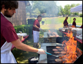 flames are shooting up the grills at a catered corporate bbq on Long Island