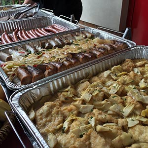 an assortment of food trays to be served at a BBQ