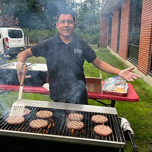 A chef grilling on a barbecue, showcasing culinary skills in a outdoor atmosphere.