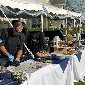 appetizer table set up at an outdoor wedding, alongside an oyster bar
