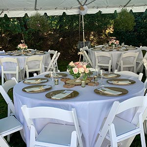 backyard wedding guest tables set up under a white tent