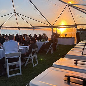 Backyard wedding set up with clear tent & sunset