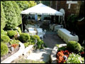 small white party tent and tables set in a back yard for a private catered party