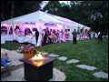catered Long Island wedding with a party tent set up in the back yard and a lit bonfire