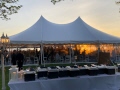 Sun is setting over a waterfront wedding tent